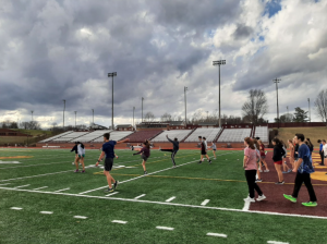 Track athletes going through warm-up drills before a strenuous workout.
