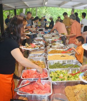 Community members enjoy fresh fruit and traditional dishes under a Bays Mountain shelter