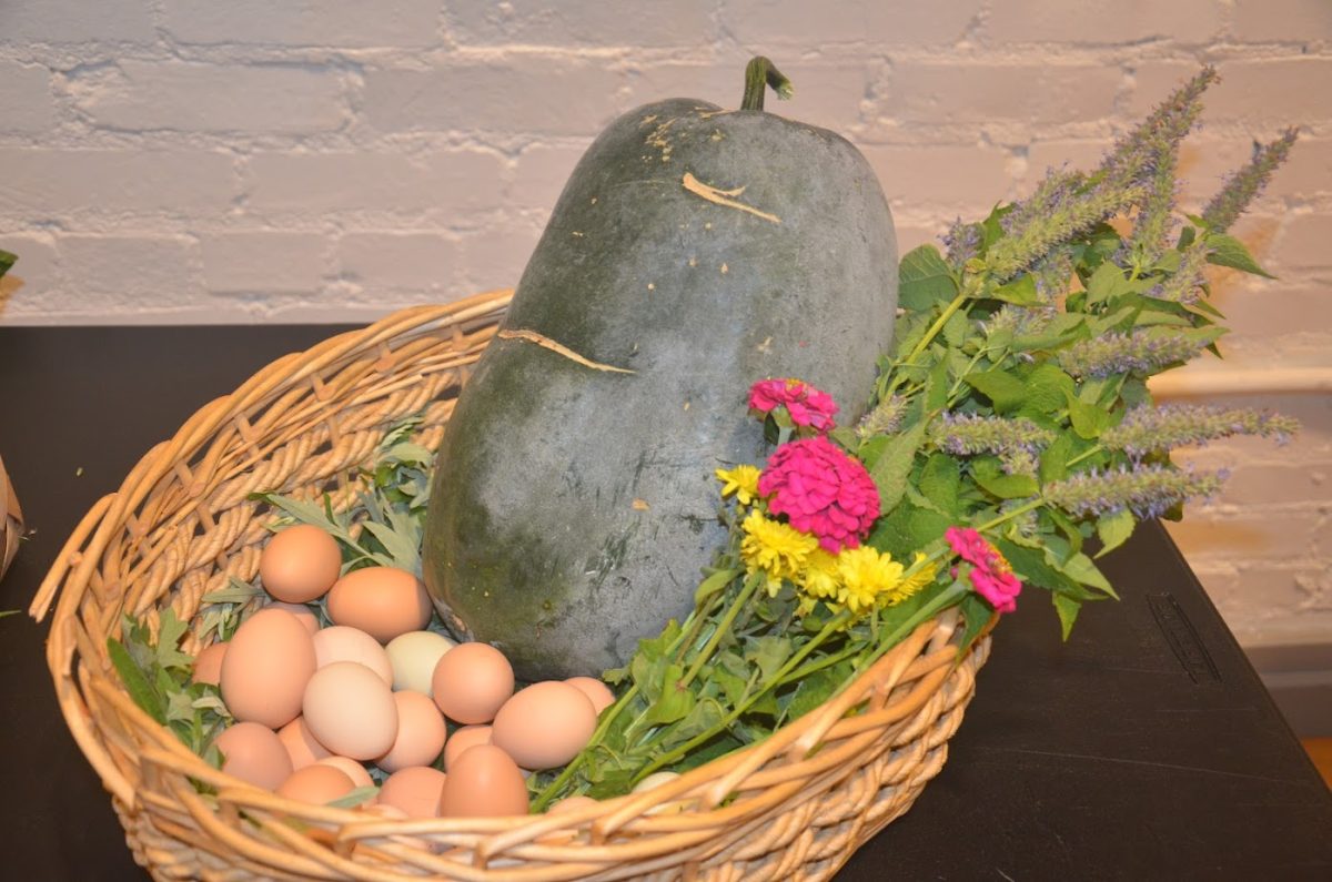 A harvest basket with winter melon and fresh eggs. 